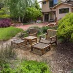 Lounge chairs in California native grass backyard meadow, patio, garden room with manzanita shrubs and deer grass (Muhlenbergia); Simons California native plant garden, Bringing Back the Natives